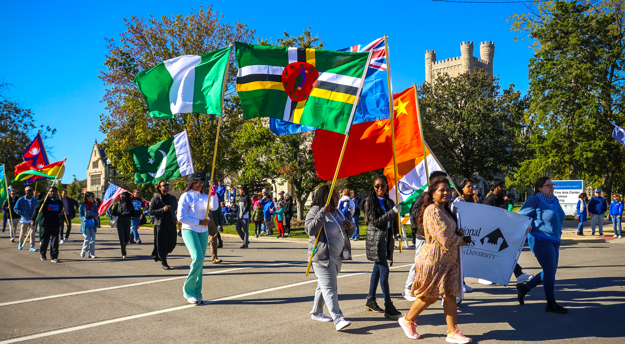 international students at homecoming parade with country of origin flags
