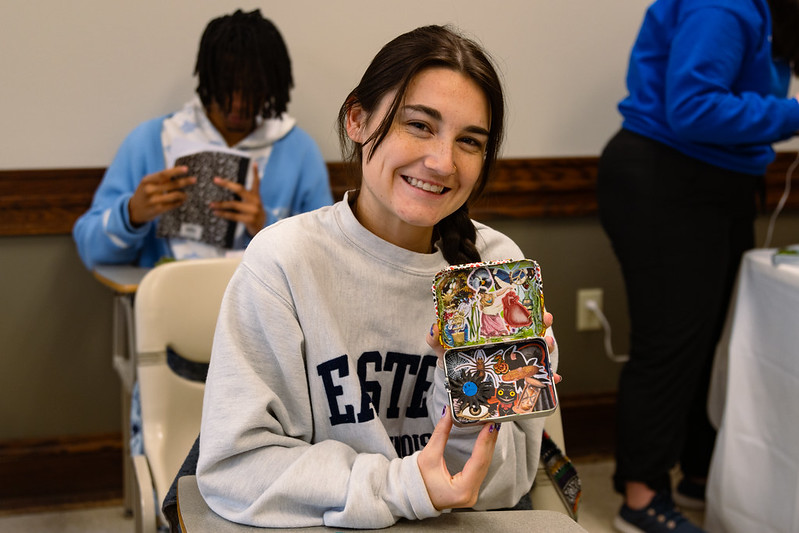 girl holding miniature tin